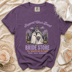 Purple t-shirt with "Bride Store" graphic featuring ghosts in wedding attire, pumpkins, and church.