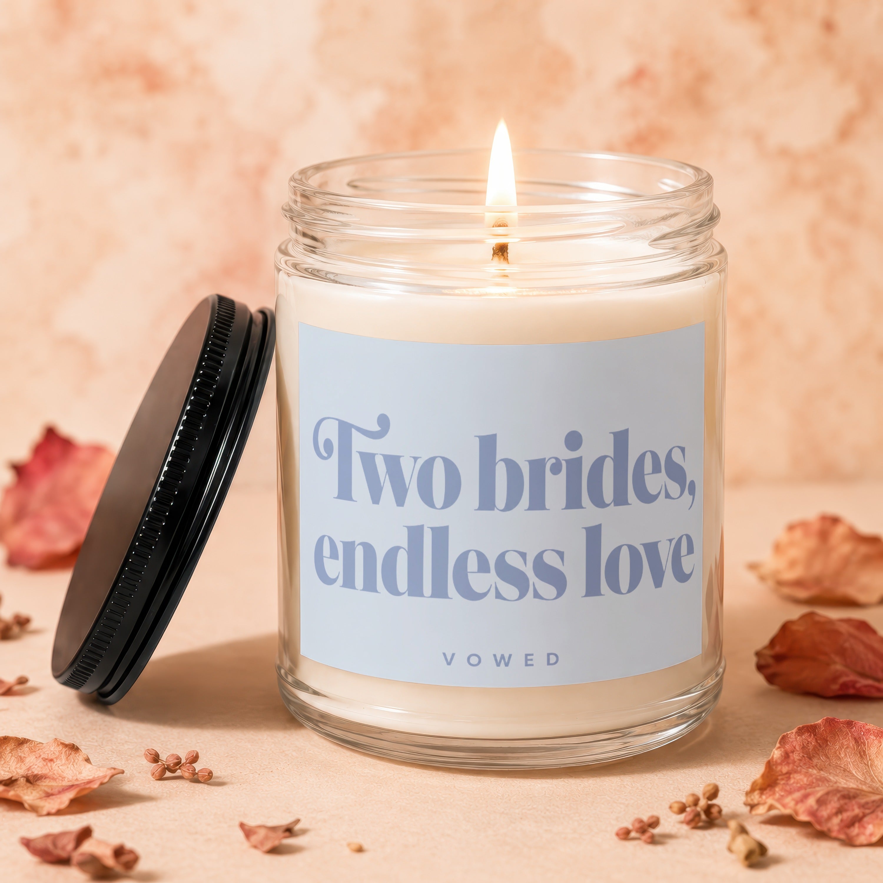 Candle with text "Two brides, endless love" and "vowed" on its label.