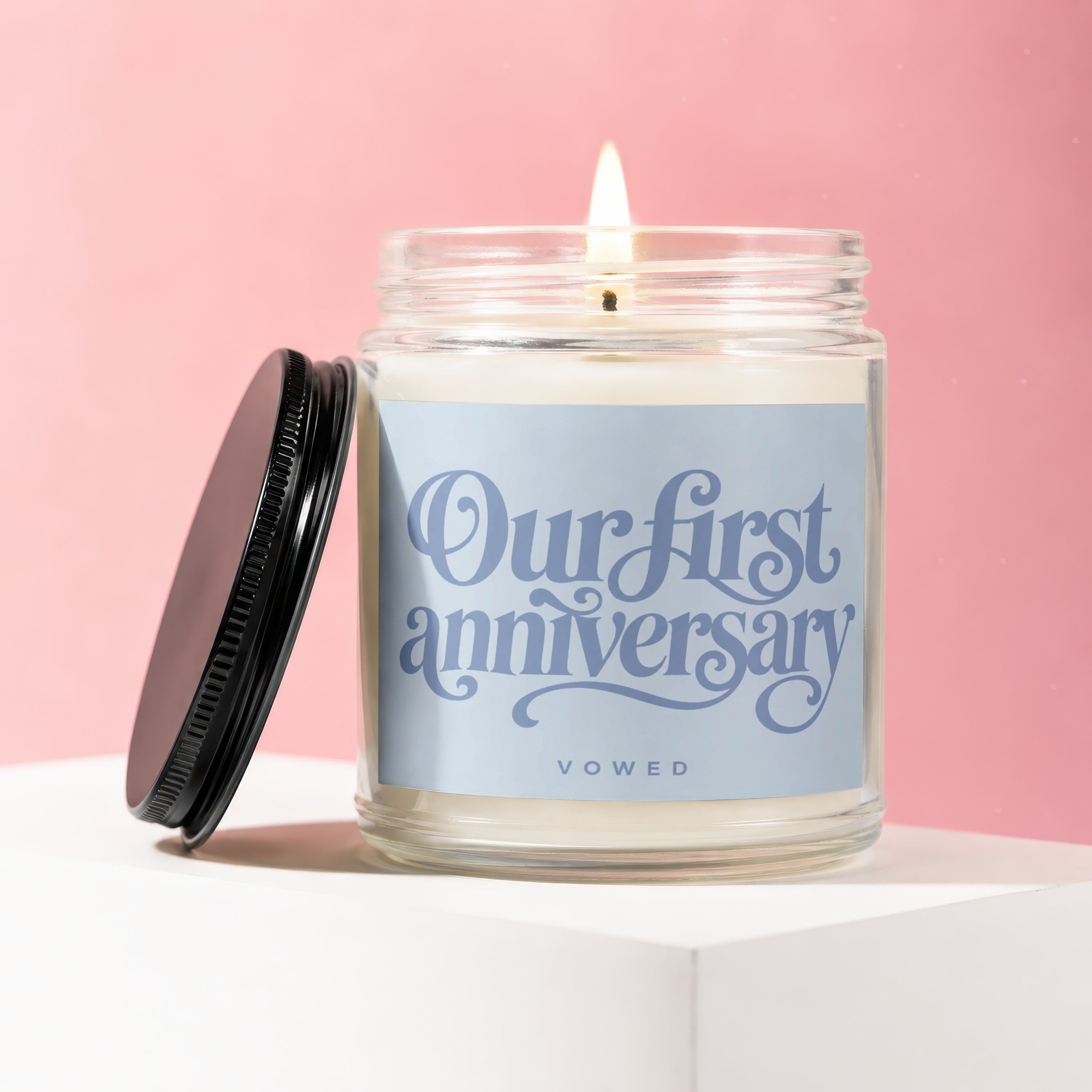 Candle with lit wick, has label "Our first anniversary" and "VOWED".