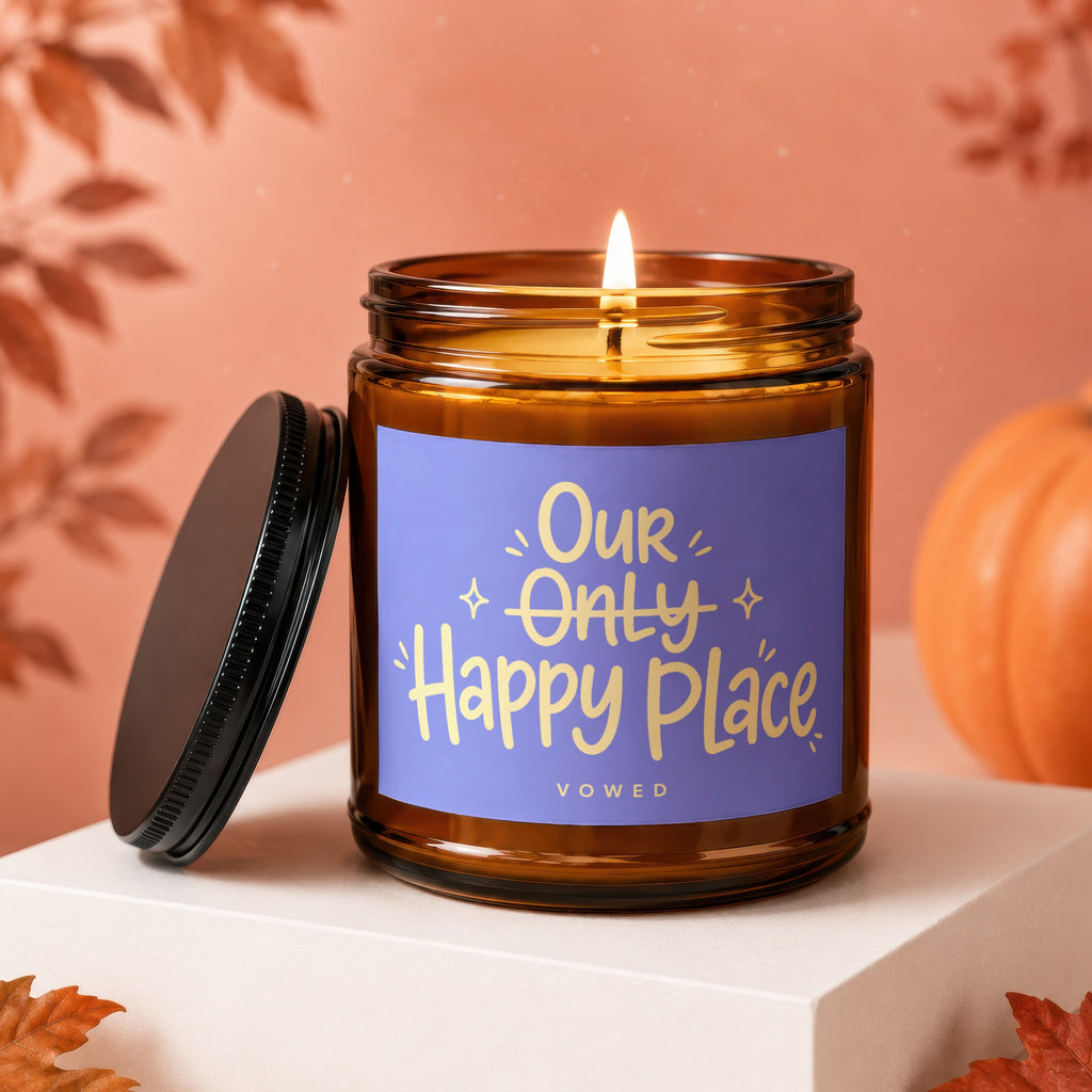 Amber jar candle with lit wick and "Our Only Happy Place" text.