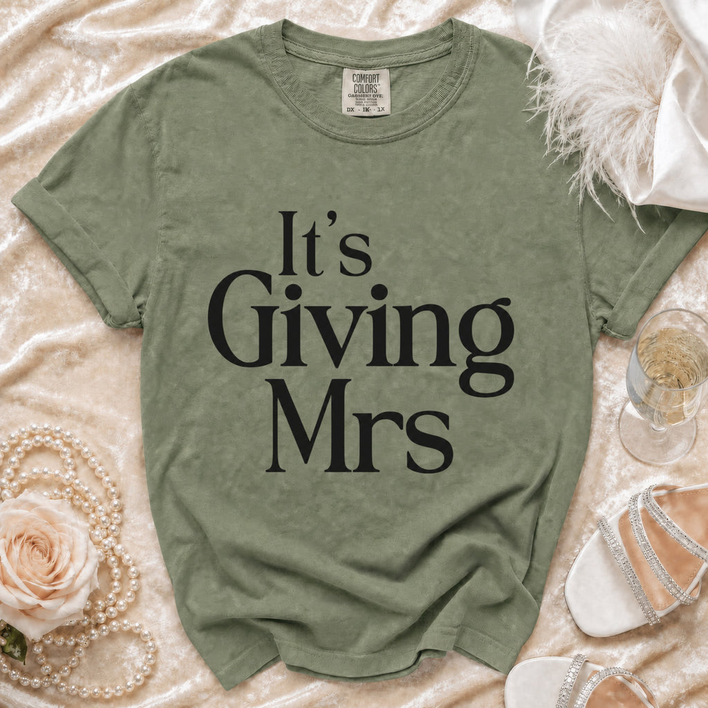 Olive green t-shirt with black text "It's Giving Mrs"