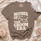 Brown t-shirt with "Mother of the Groom Era" text and heart-shaped glasses graphic.
