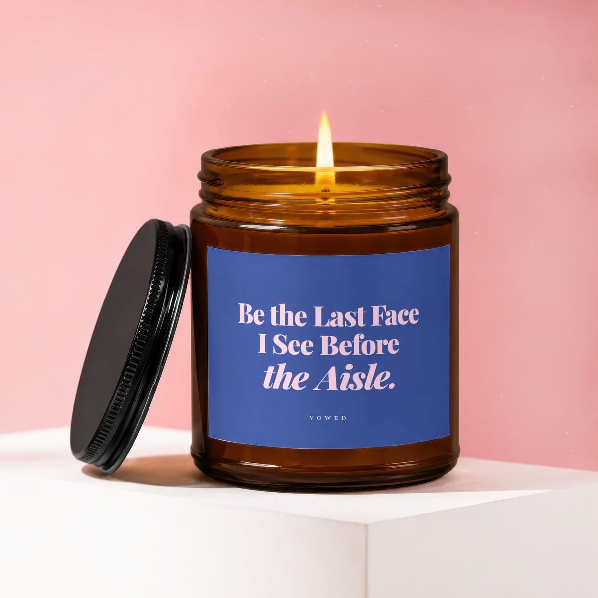 Amber candle with lit wick, blue label reads "Be the Last Face I See Before the Aisle. VOWED".