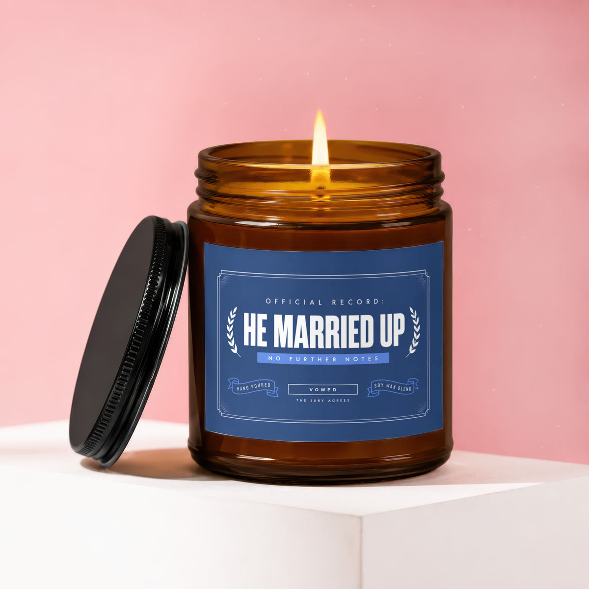 Lit candle in amber jar with blue label: "HE MARRIED UP", "VOWED", "THE JURY AGREES".