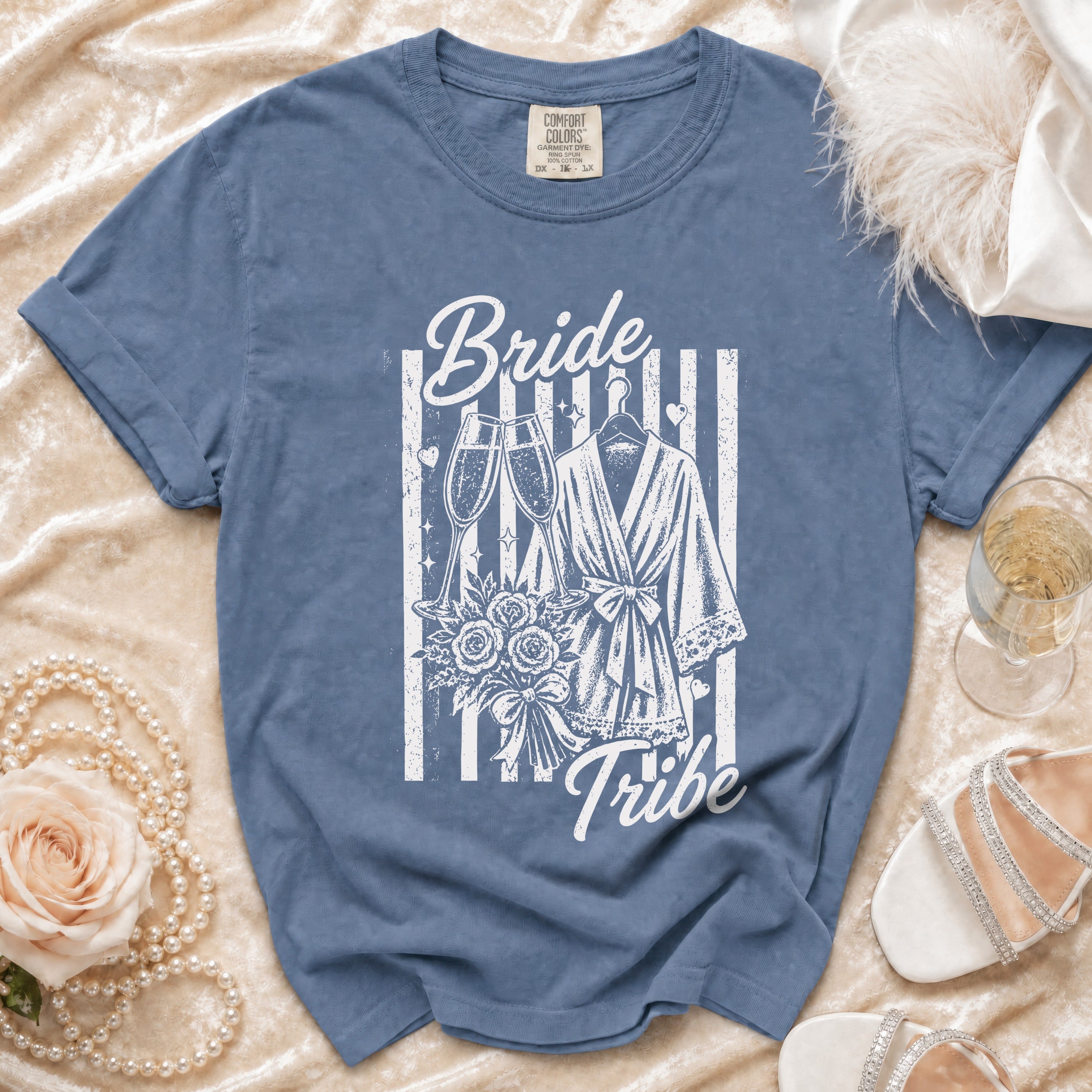 Blue t-shirt with "Bride Tribe" graphic featuring champagne, bouquet, and robe.
