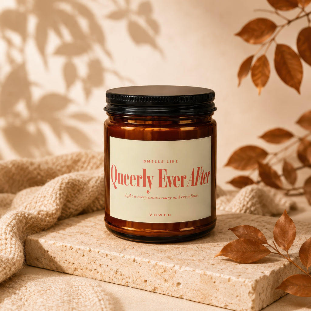 Amber jar candle labeled "Queerly Ever After" with vow collection detail.
