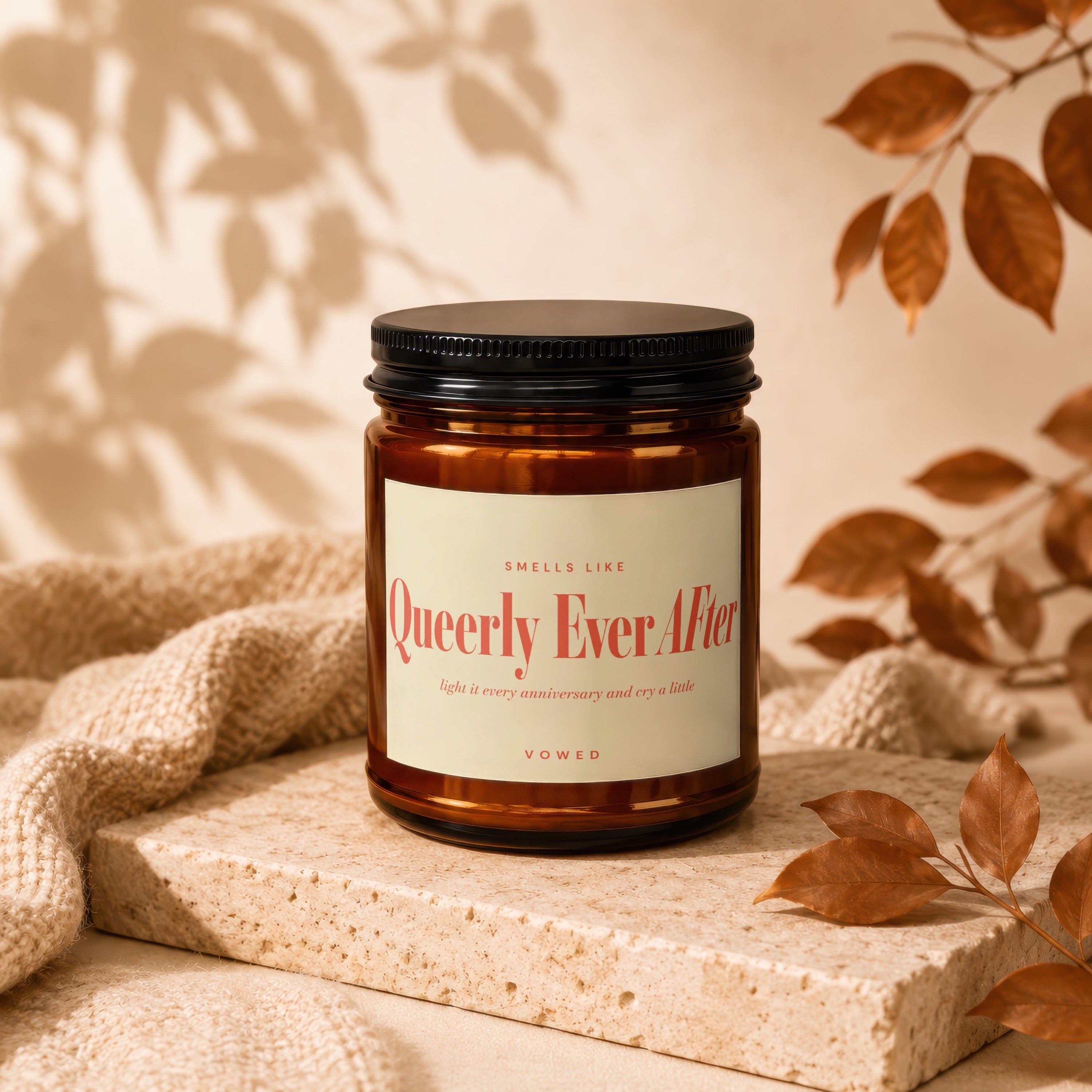 Amber jar candle labeled "Queerly Ever After" with vow collection detail.