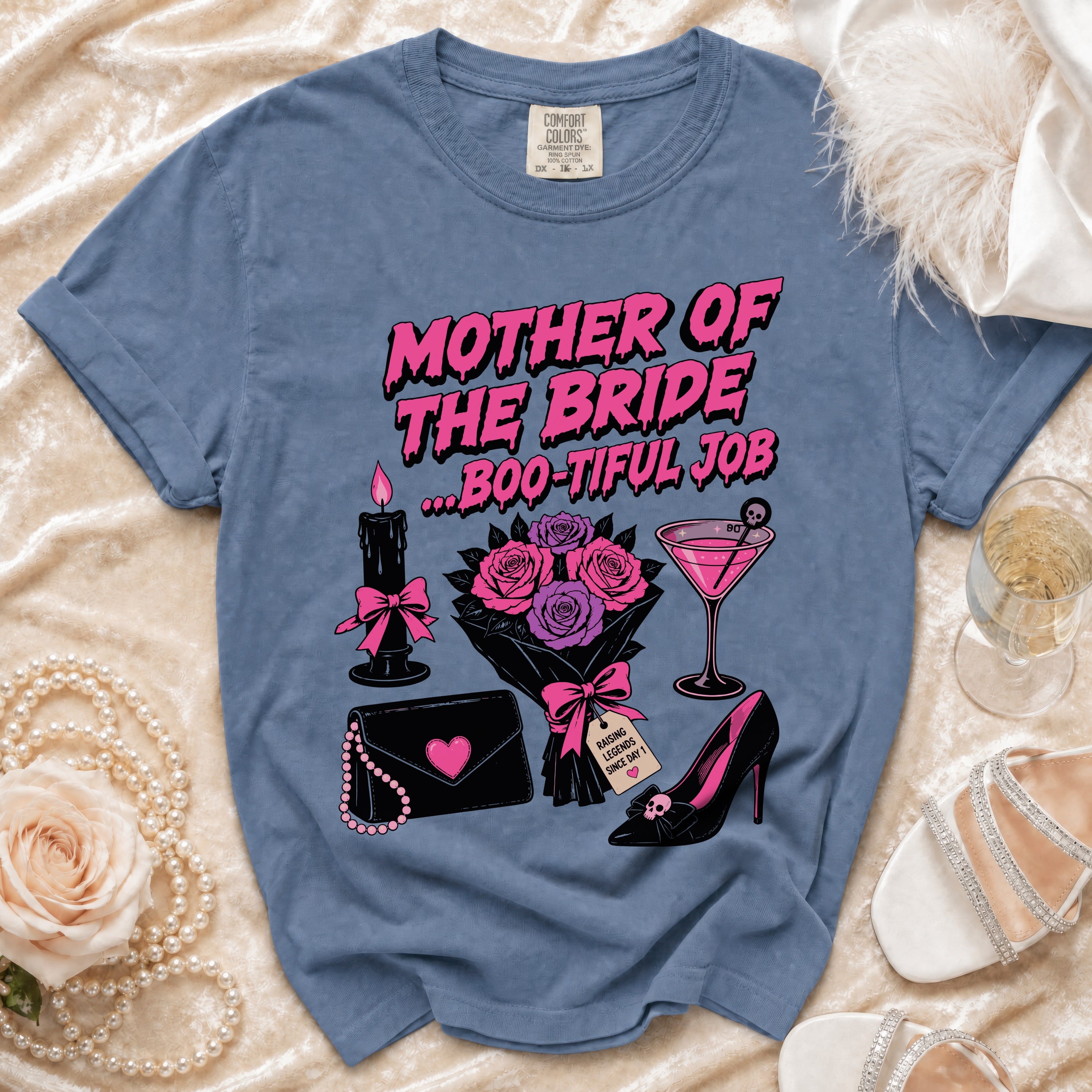 Blue shirt with "Mother of the Bride ...Boo-tiful Job" graphic, black candle, flowers, purse, and shoe.
