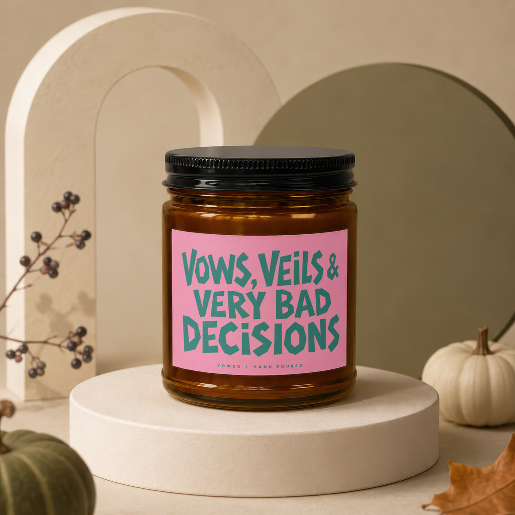 Candle with pink label reading "Vows, Veils & Very Bad Decisions".