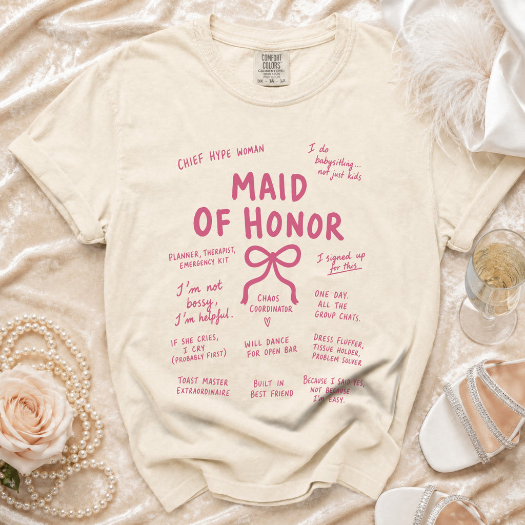 Cream t-shirt with "Maid of Honor" and wedding party roles printed in pink.