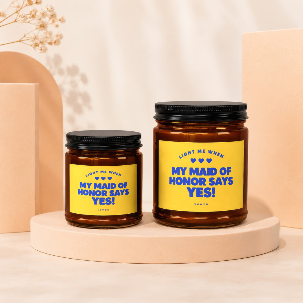 Two amber candles with yellow labels that read "My Maid of Honor Says Yes!".