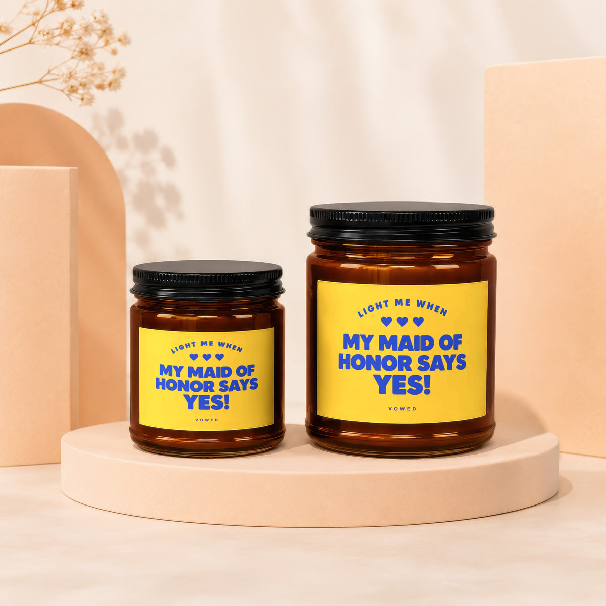 Two amber candles with yellow labels that read "My Maid of Honor Says Yes!".