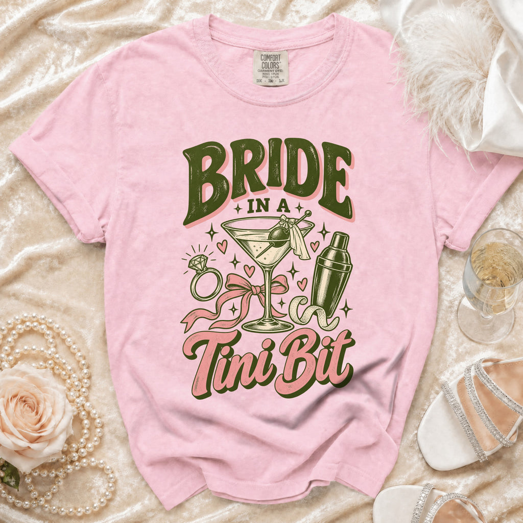 Pink t-shirt with "Bride in a Tini Bit" graphic, martini, shaker, and ring.