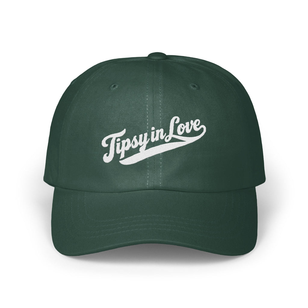A dark green baseball cap featuring white embroidered text that reads Tipsy in Love across the front.