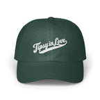 A dark green baseball cap featuring white embroidered text that reads Tipsy in Love across the front.