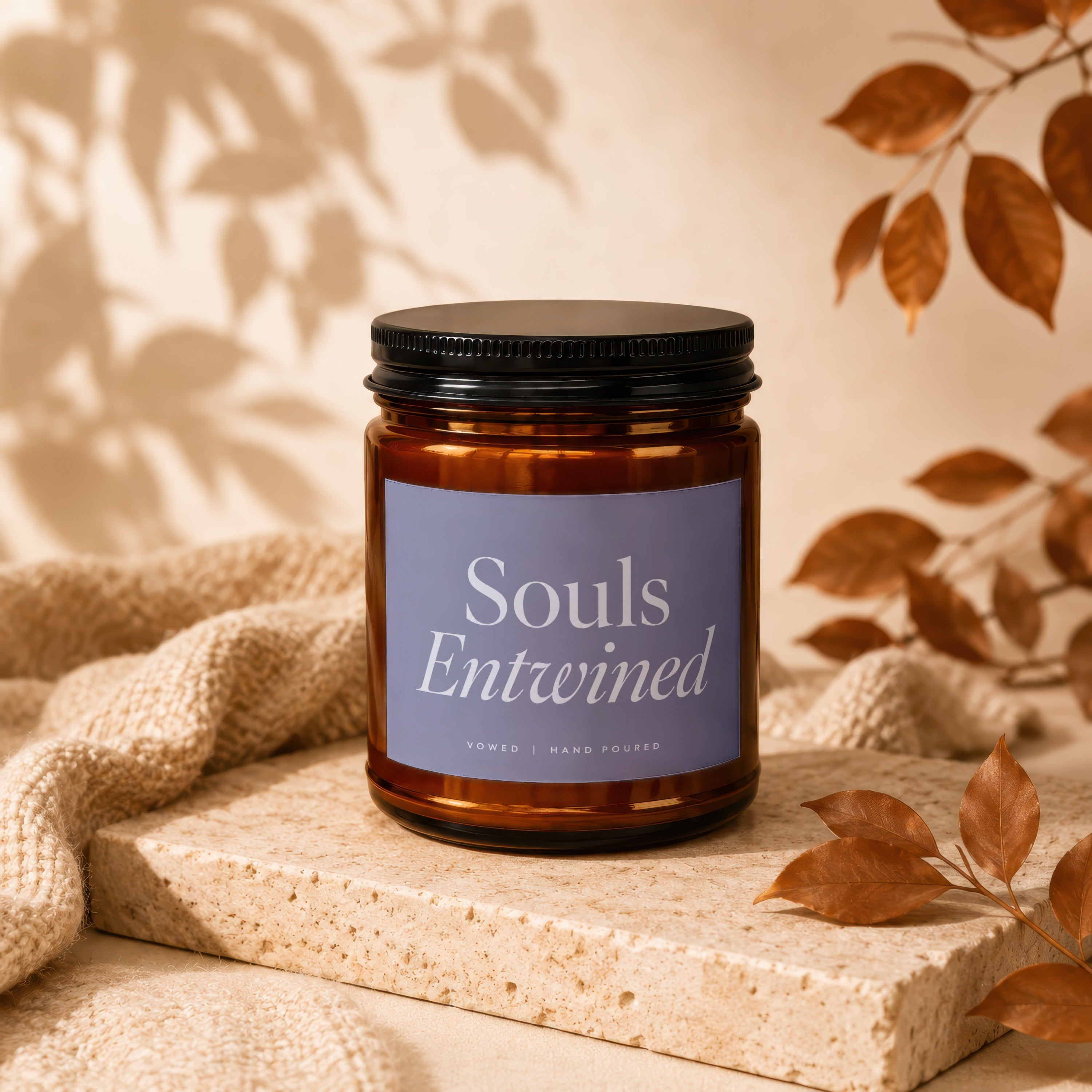 Amber glass candle with lavender label reading "Souls Entwined", "vowed | hand poured".