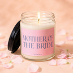 Glass candle with pink label reading "MOTHER OF THE BRIDE" surrounded by flower petals.