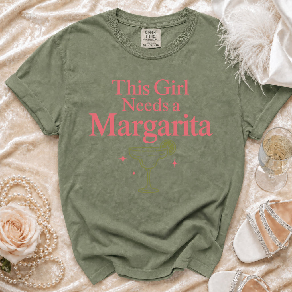 Green t-shirt with pink text "This Girl Needs a Margarita" and margarita graphic.