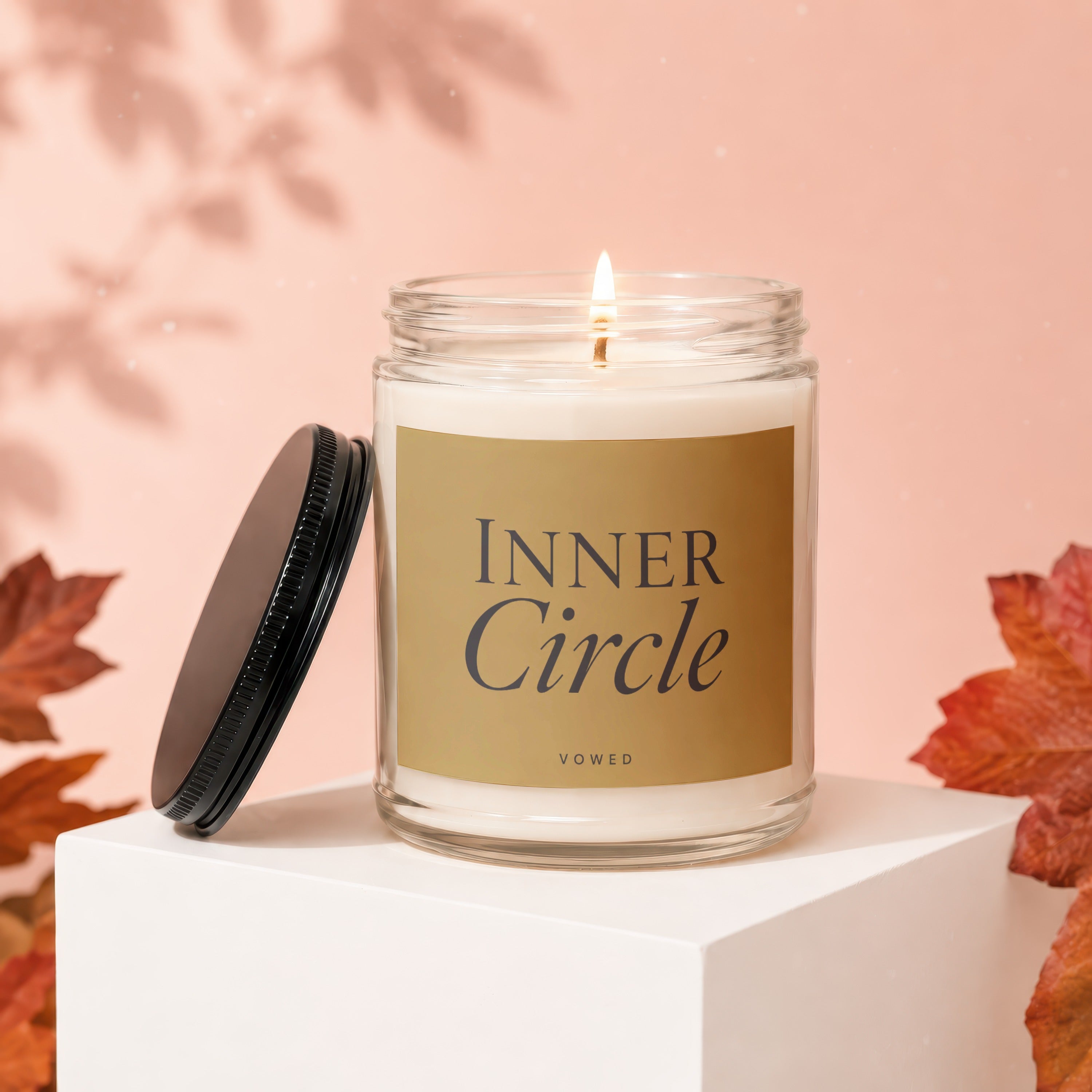 Lit candle in glass jar with gold label reading "Inner Circle Vowed".