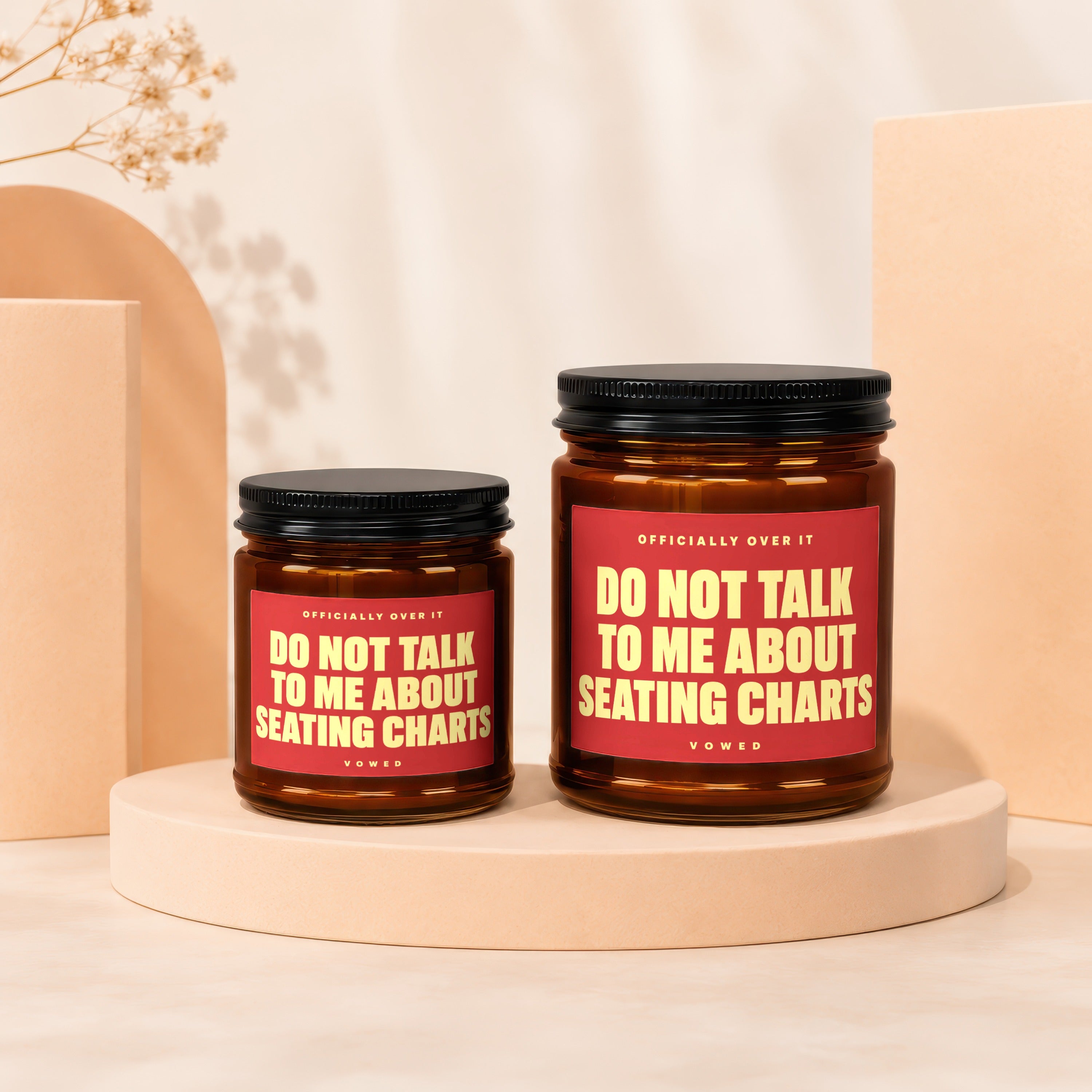 Two brown glass candles with red labels that read "Do Not Talk To Me About Seating Charts".