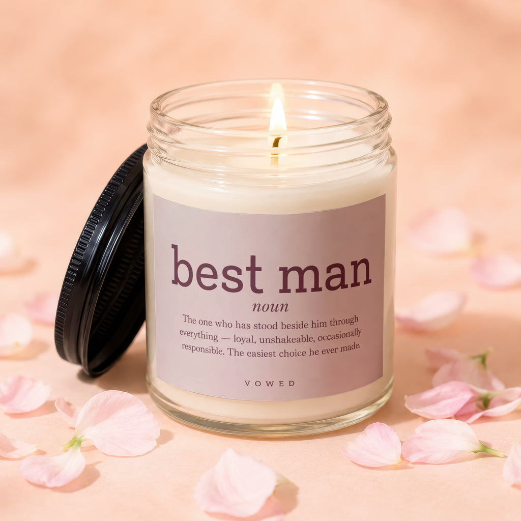 Lit candle in glass jar with "best man noun" definition label and scattered petals.