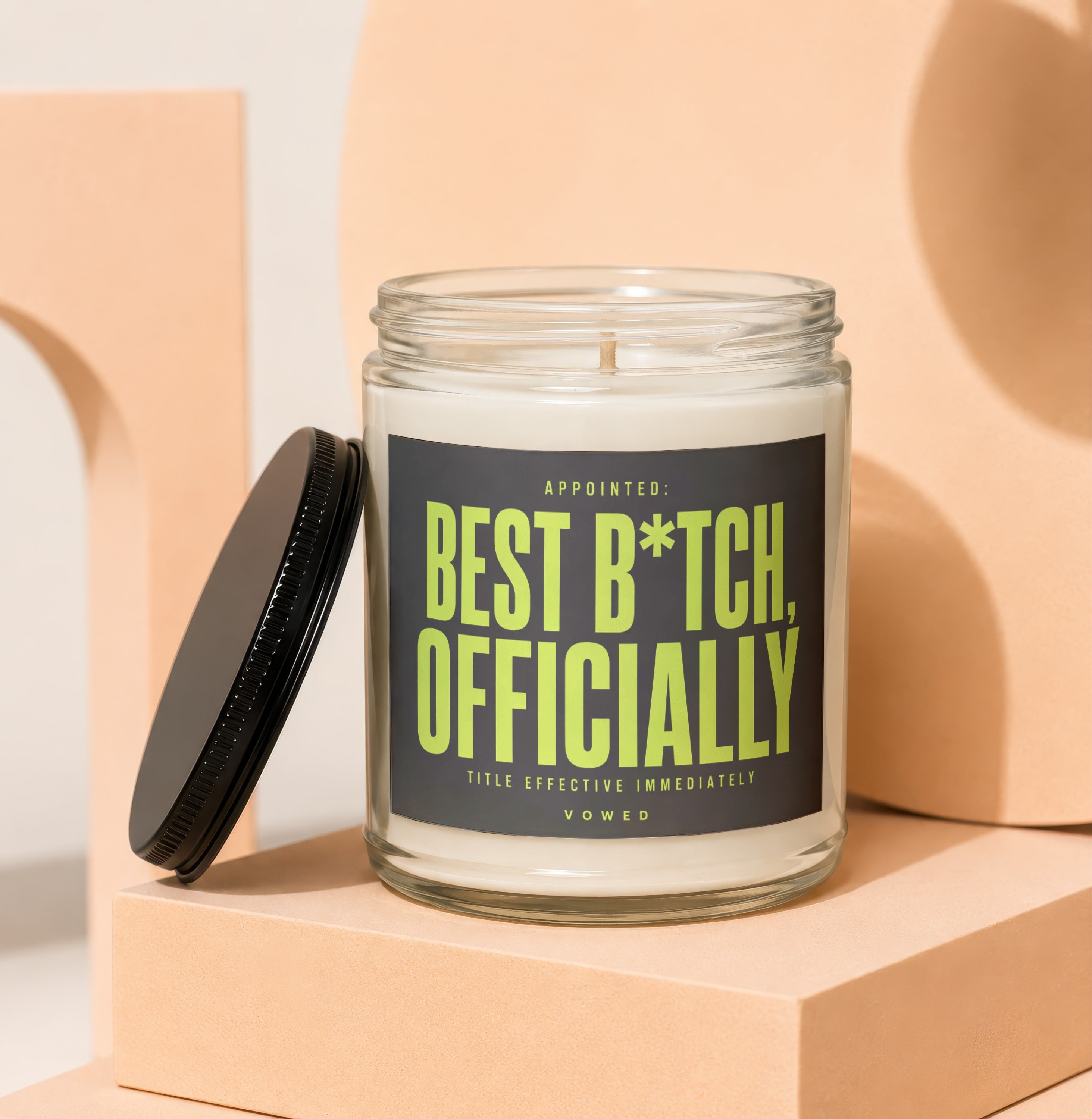 Glass jar candle with black lid, reading "Appointed: Best B*tch, Officially".