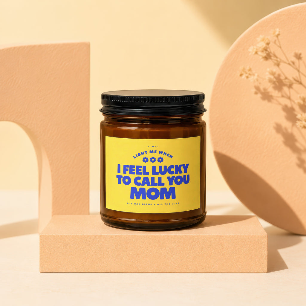 Glass candle with yellow label reading "I FEEL LUCKY TO CALL YOU MOM".