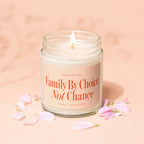 Candle with lit wick and label reading "Smells like Family by Choice, Not Chance."