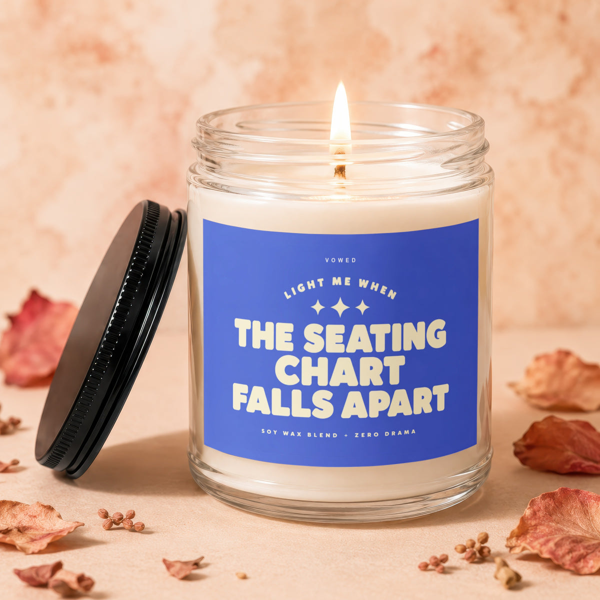 Candle with blue label reading "Light me when the seating chart falls apart".