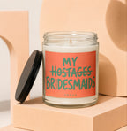 Glass candle with "My Hostages Bridesmaids" text on coral label.