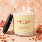 Glass jar candle with burning wick and label reading "officiant" and definition.