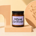 Amber jar candle labeled "Official Spellcaster, Credentials on File, Vowed".