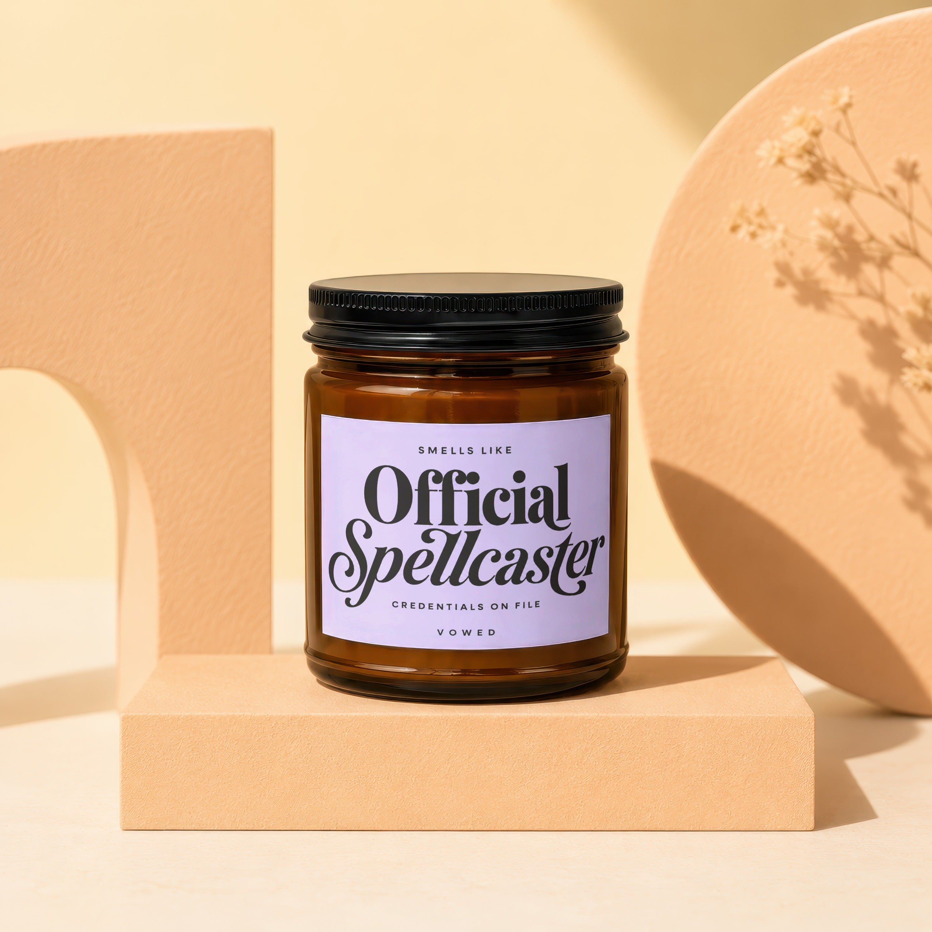 Amber jar candle labeled "Official Spellcaster, Credentials on File, Vowed".