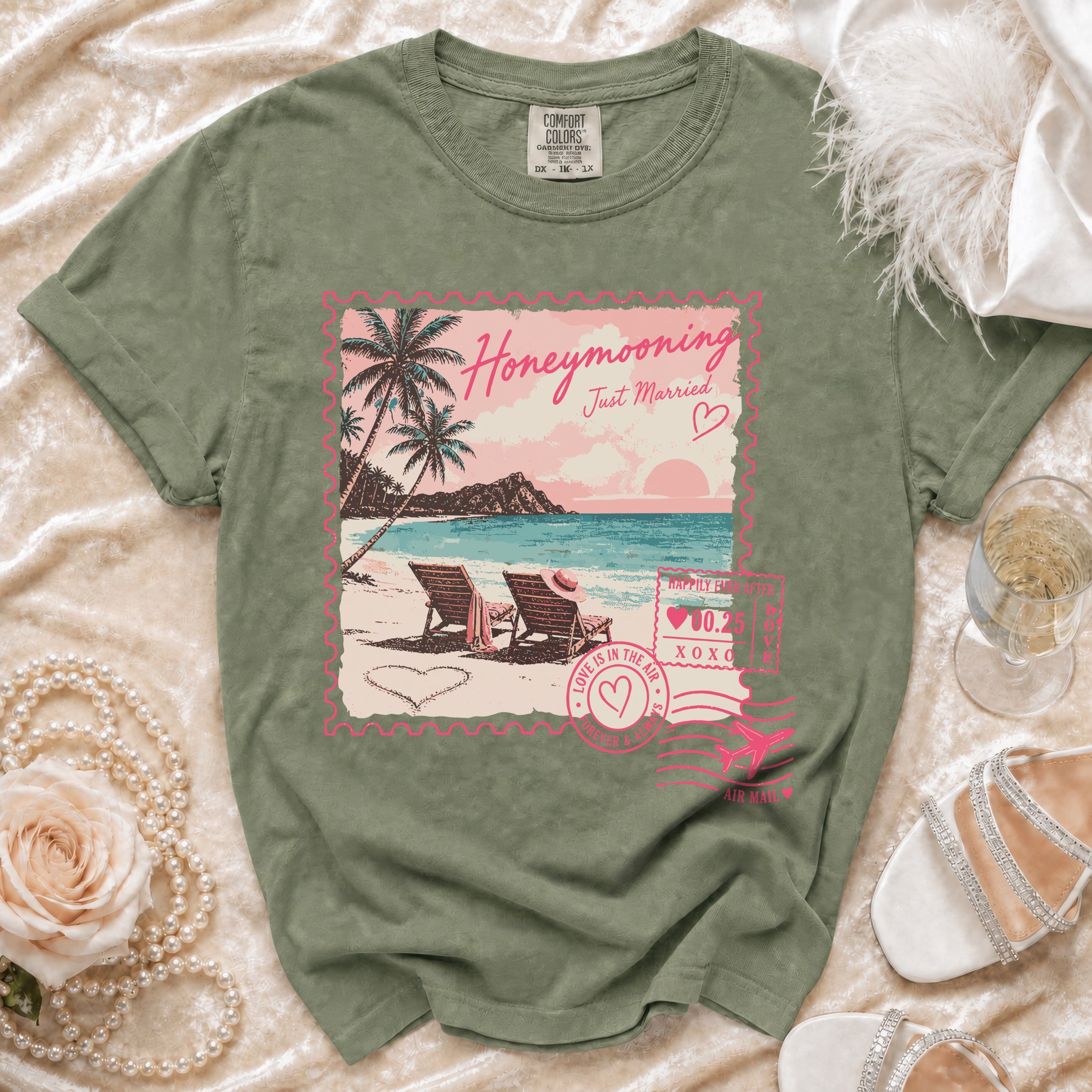 Olive green t-shirt with "Honeymooning Just Married" floral beach stamp graphic.