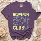 Purple t-shirt with "Groom Mom Club" text and wedding icons.