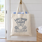 Last Toast On The Coast canvas tote hanging on a hook in a beach house