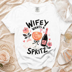 White t-shirt with "Wifey Wants a Spritz" graphic, prosecco, and cocktail.