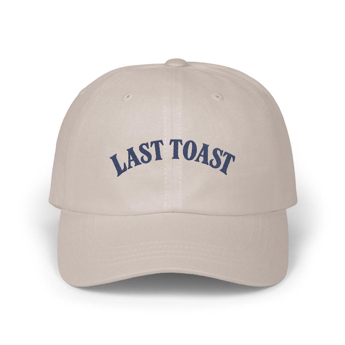 Light tan baseball cap with "LAST TOAST" embroidered in navy blue.
