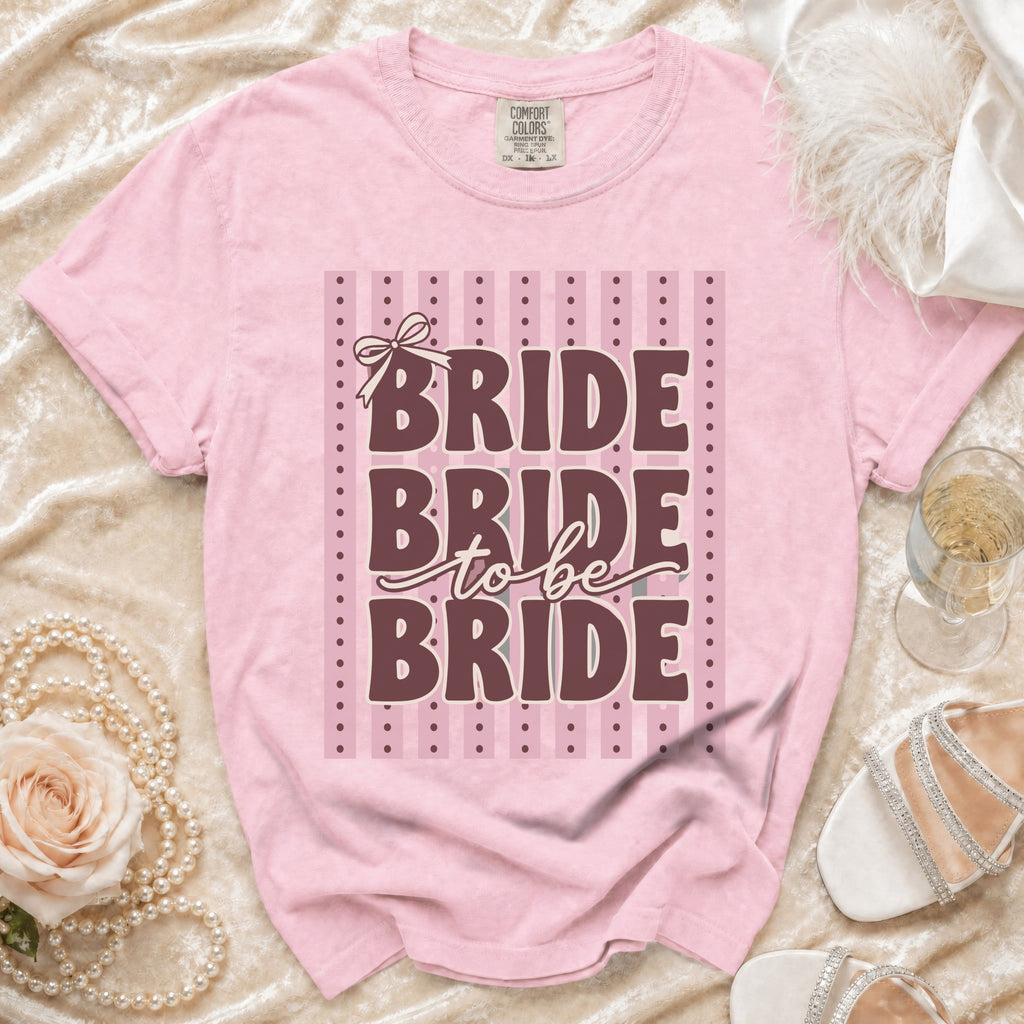 Pink t-shirt with "BRIDE to be BRIDE" text and bow detail.