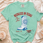 Comfort Colors t-shirt with "Reckless in Texas" design featuring a boot and disco ball.
