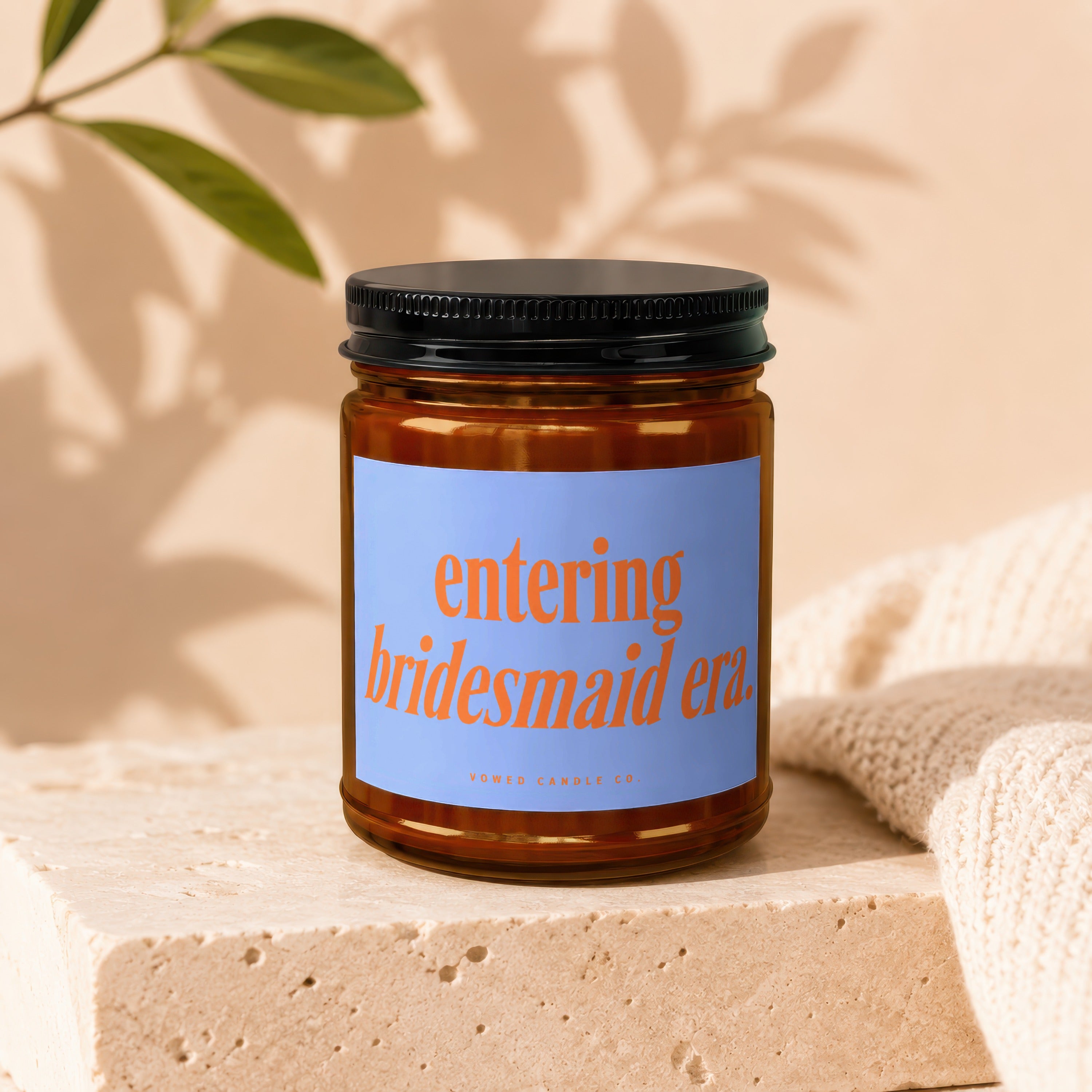 Amber candle with blue label reading "entering bridesmaid era", by Vowed Candle Co.
