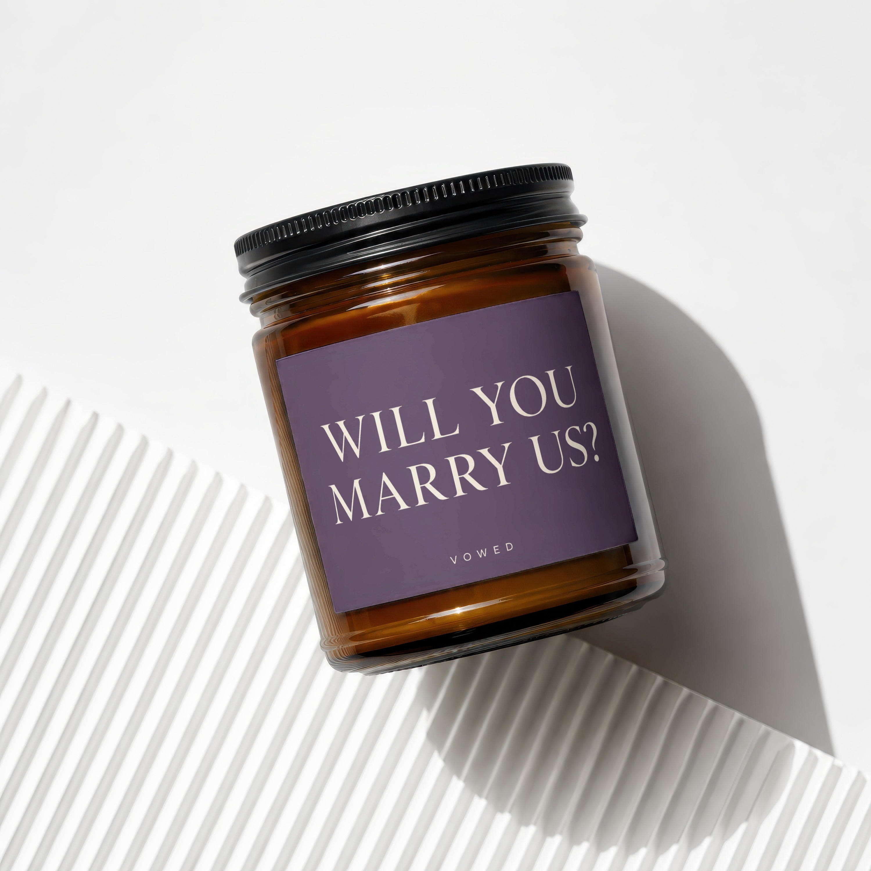 Amber glass candle with "WILL YOU MARRY US?" text on purple label.