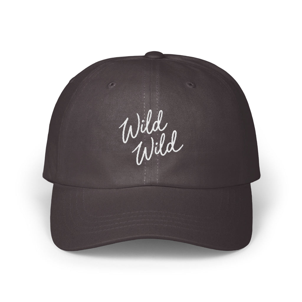 A dark charcoal baseball cap featuring the embroidered white text Wild Wild centered on the front panels.