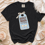 Black t-shirt with "HONEY MOON in progress" text and champagne glasses graphic.