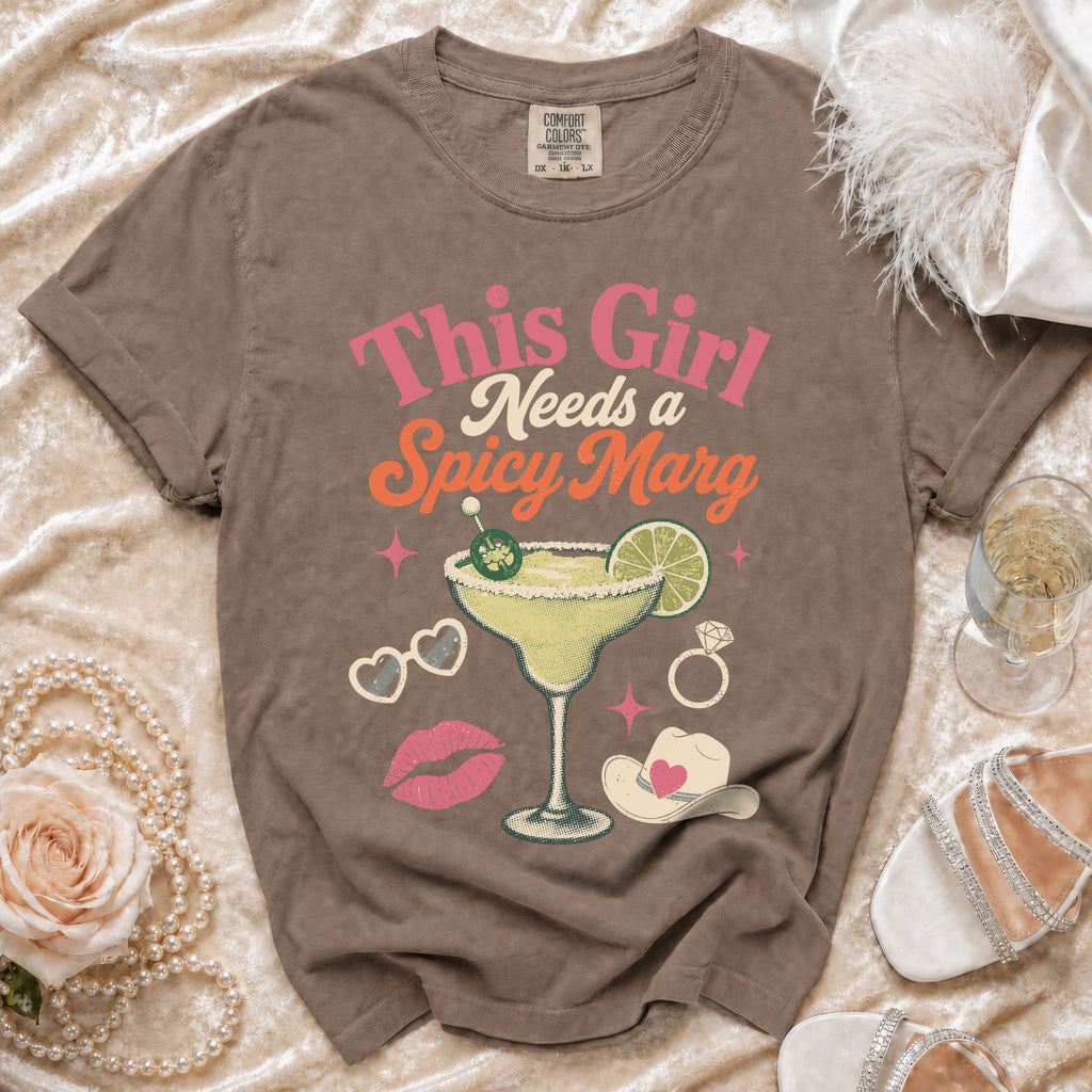 Brown t-shirt with graphic text "This Girl Needs a Spicy Marg" and margarita imagery.