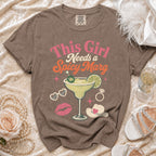 Brown t-shirt with graphic text "This Girl Needs a Spicy Marg" and margarita imagery.