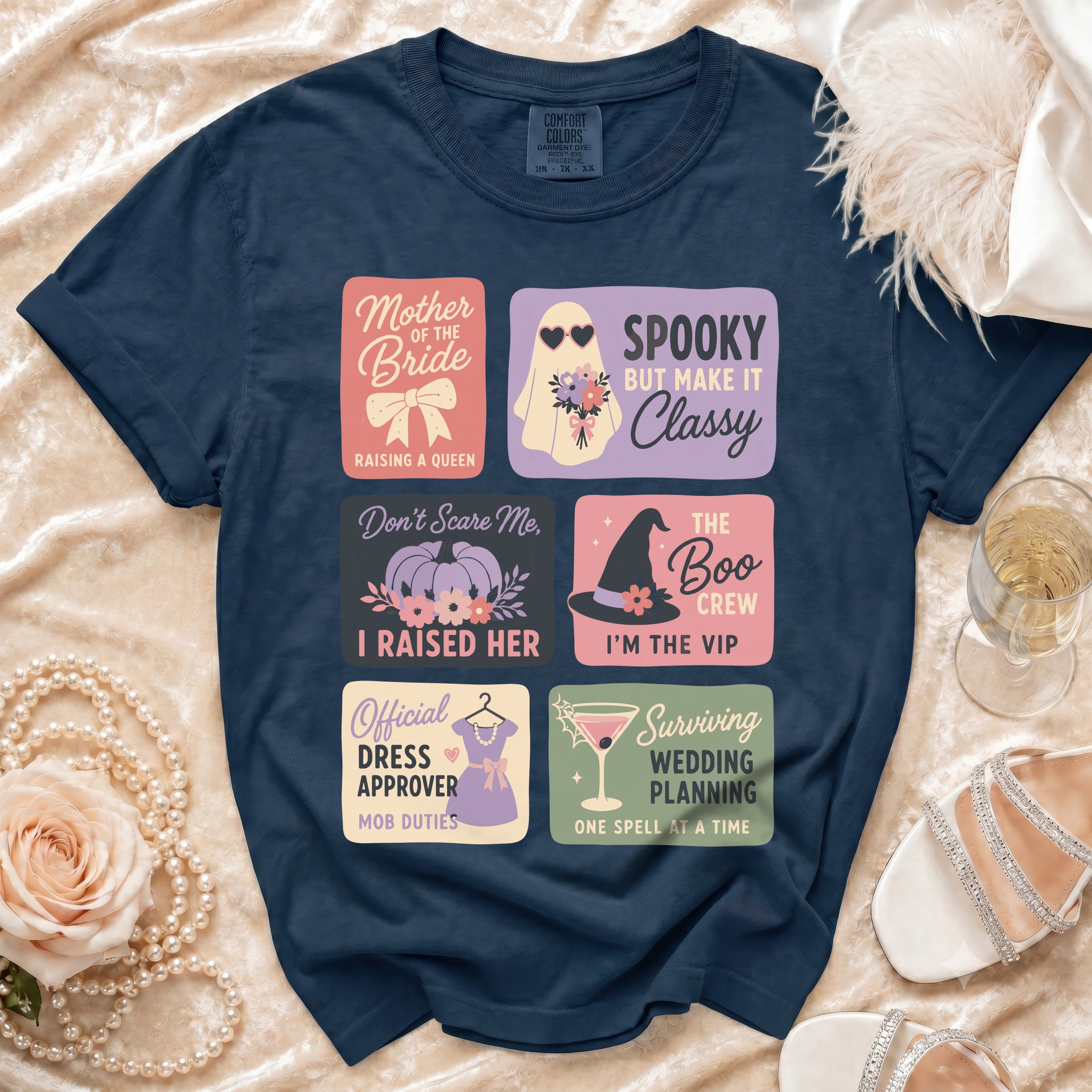 Navy t-shirt with six Halloween-themed wedding squares: Mother of the Bride, Spooky but Make It Classy, Don't Scare Me I Raised Her, The Boo Crew I'm the VIP, Official Dress Approver Mob Duties, Surviving Wedding Planning One Spell at a Time.