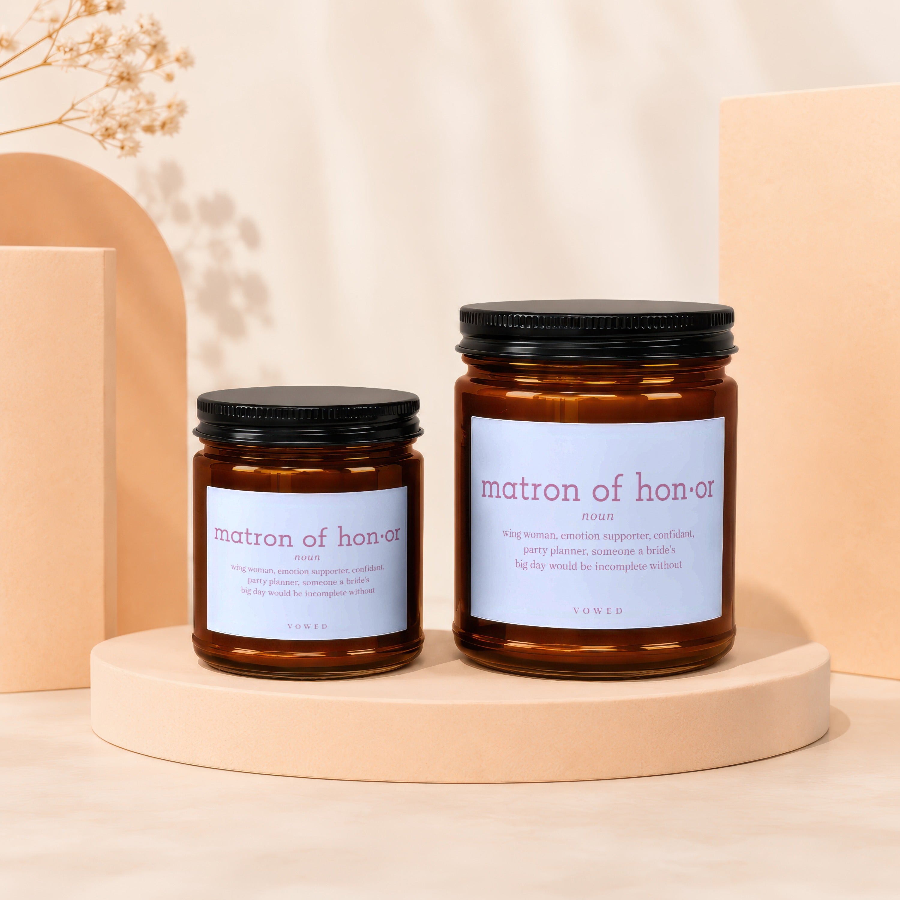 Two amber glass candles with black lids, labeled "matron of honor".