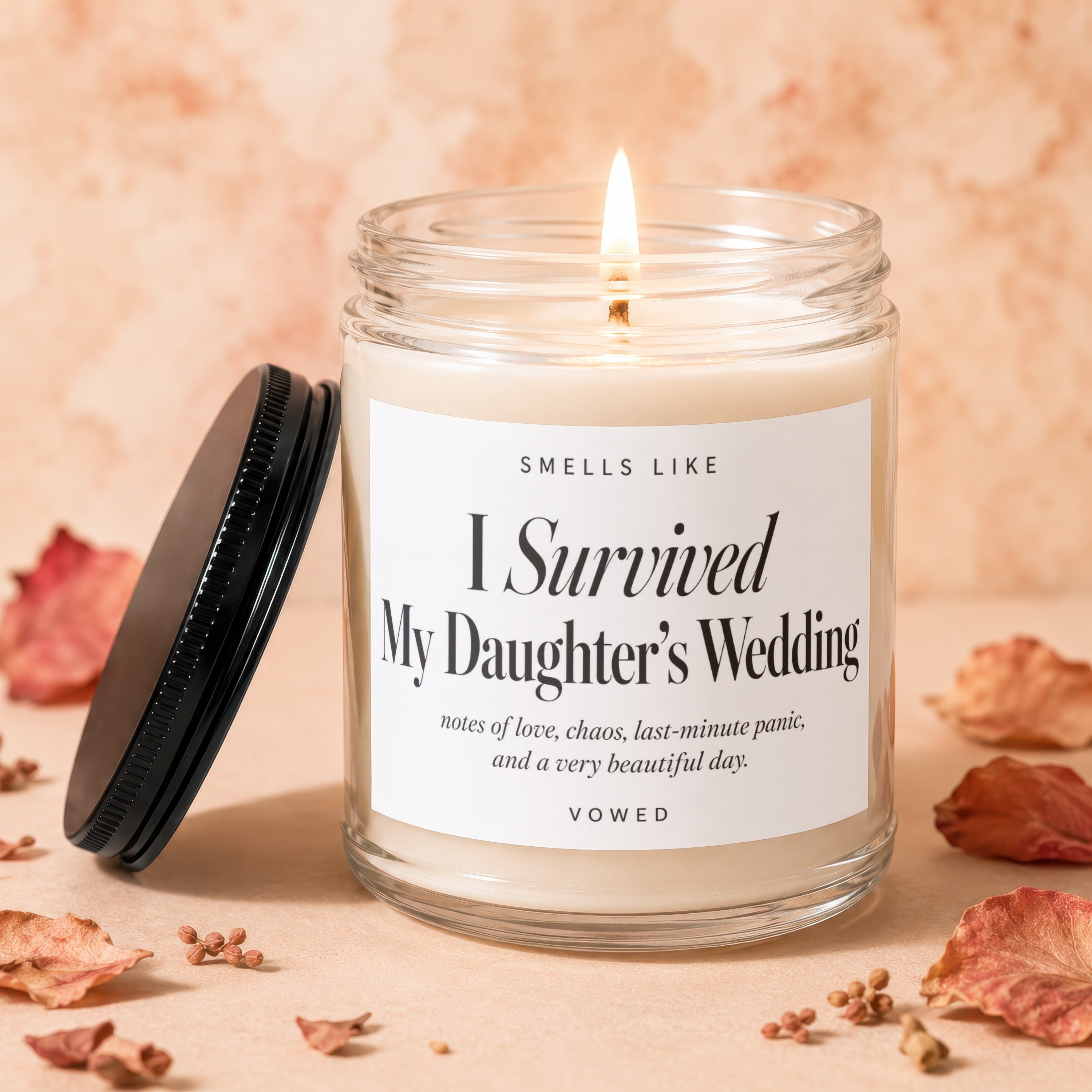 Candle labeled "I Survived My Daughter's Wedding" with a lit wick.