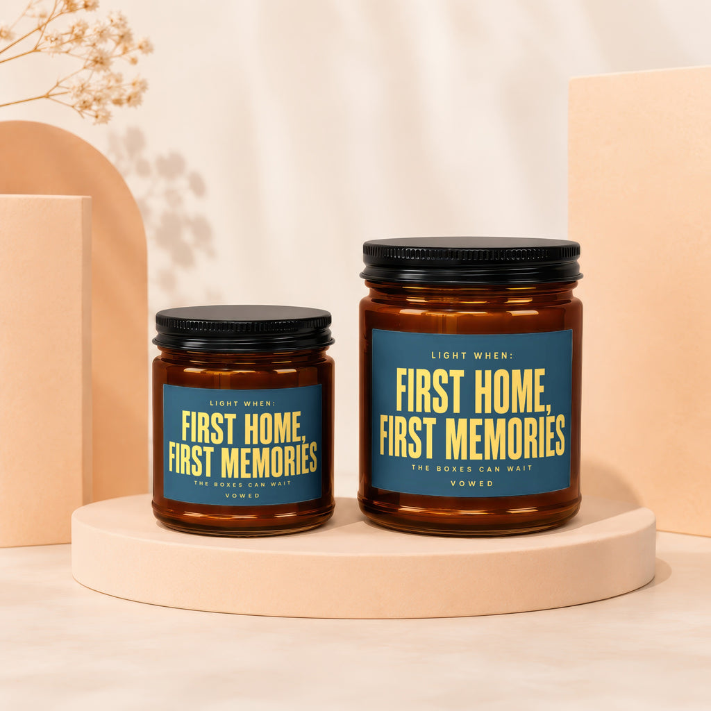 Two brown glass candles with dark lids and blue labels reading "First Home, First Memories."